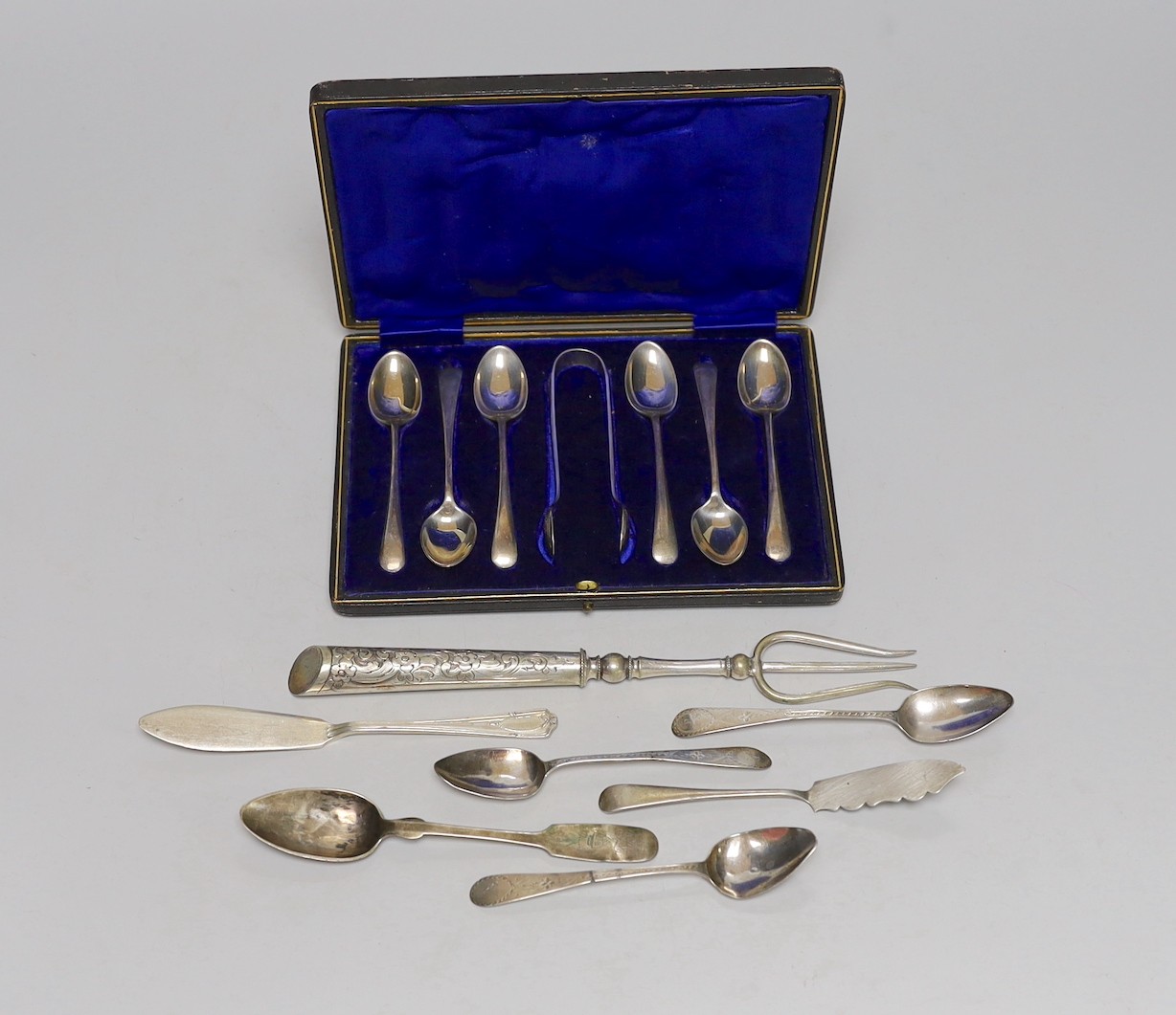 A cased set of six George V silver teaspoons, with sugar tongs and seven other items of silver or white metal flatware.